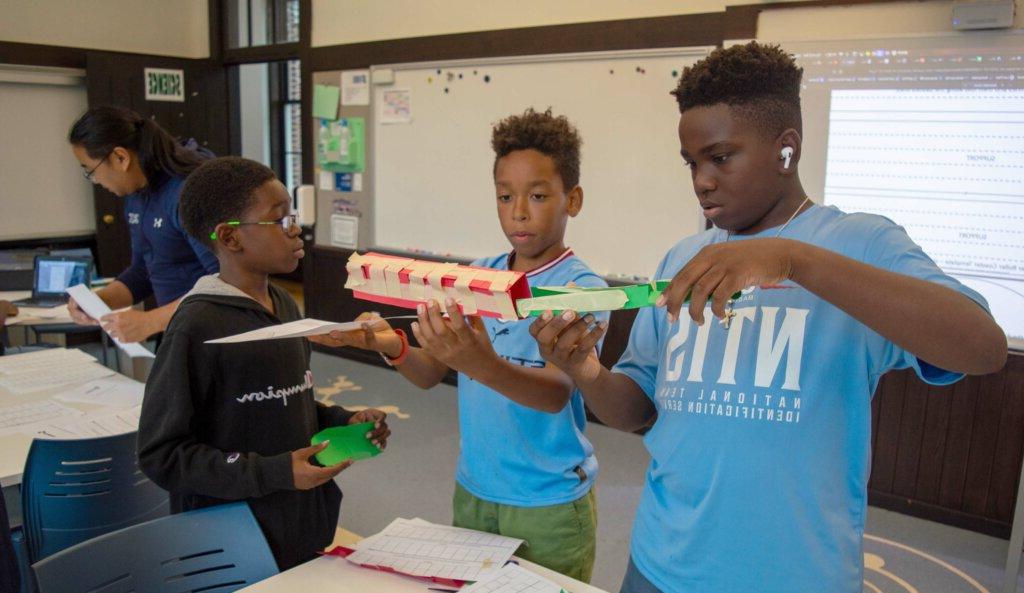 Asher Blumberg, Grayson Daley, Malakhi Seales collaborating in the classroom